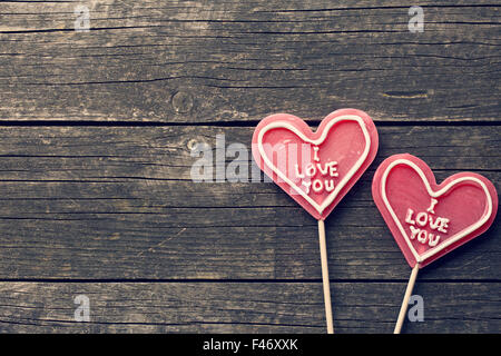 Lecca-lecca cuore su un annata sullo sfondo di legno Foto Stock