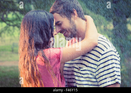 Carino coppia abbracciando sotto la pioggia Foto Stock