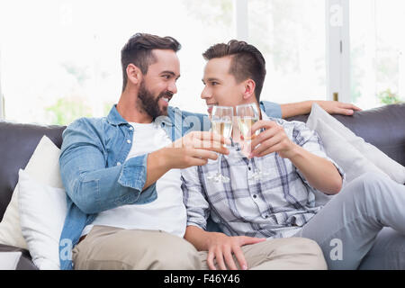 Coppia omosessuale uomini la tostatura con un flute da champagne Foto Stock