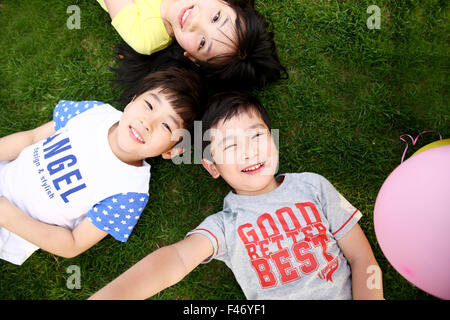 Bambini sdraiati sull'erba Foto Stock