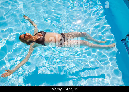 Donna incinta IN UN POOL Foto Stock