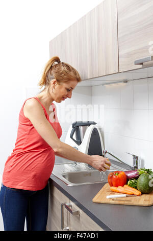 Donna incinta IN CUCINA Foto Stock