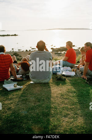 Un grande gruop di persone mangiare la pizza nel tramonto, Svezia. Foto Stock