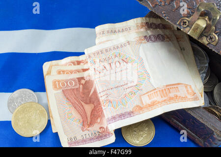 Il greco antico dracma valuta banconote cadere al di fuori della casella sulla bandiera greca Foto Stock