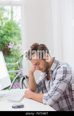 Bel uomo dorme dietro al calcolatore Foto Stock