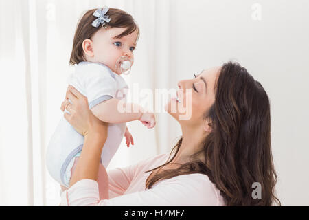 Sorridente madre a giocare con la sua bambina Foto Stock