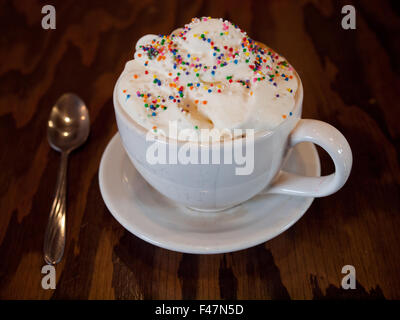 Un caldo Torta di compleanno latté con granelli colorati e panna montata dal d'Lish da Tish Café di Saskatoon, Saskatchewan, Canada. Foto Stock