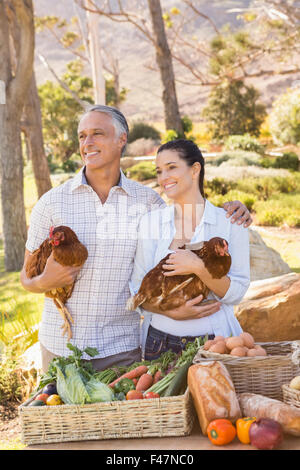 Sorridente imprenditore giovane azienda pollo e uova Foto Stock
