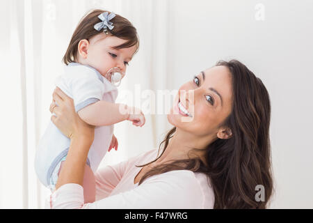 Sorridente madre a giocare con la sua bambina Foto Stock