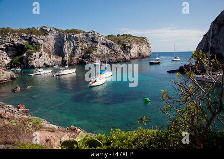 Sailing yacht ormeggiati in una appartata baia rocciosa di Calas insenature dell'isola di Minorca spagna Foto Stock