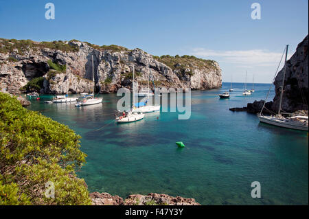 Sailing yacht ormeggiati in una appartata baia rocciosa di Calas insenature dell'isola di Minorca spagna Foto Stock