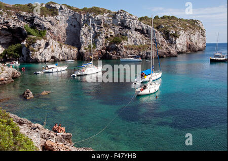 Sailing yacht ormeggiati in una appartata baia rocciosa di Calas insenature dell'isola di Minorca spagna Foto Stock