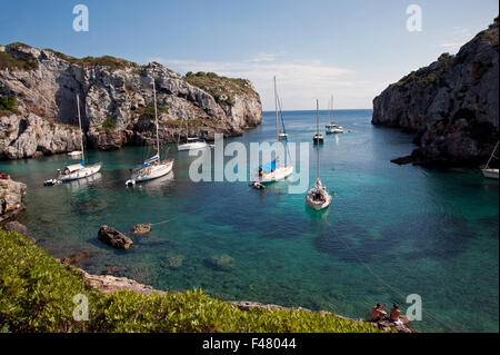 Sailing yacht ormeggiati in una appartata baia rocciosa di Calas insenature dell'isola di Minorca spagna Foto Stock