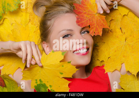 Giovane donna in Giallo autunno foglie di acero Foto Stock