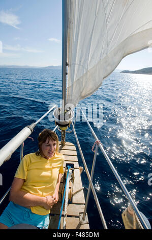 Una donna su una barca a vela in Sardegna, Italia. Foto Stock