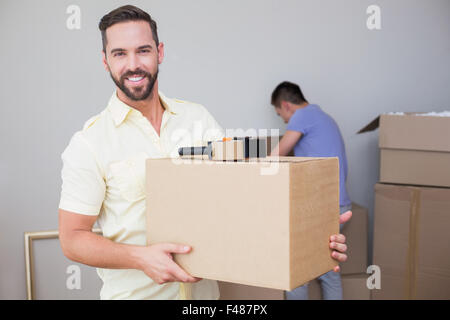 Uomo bello Holding la scatola con il suo ragazzo dietro Foto Stock