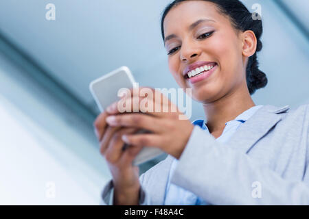 Felice imprenditrice usando il suo smartphone Foto Stock