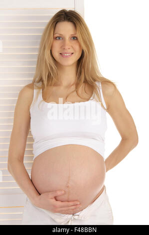 Donna incinta in piedi vicino alla porta Foto Stock