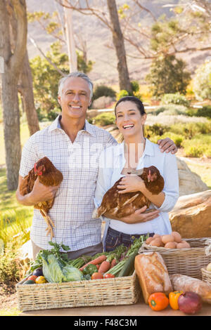 Sorridente imprenditore giovane azienda pollo e uova Foto Stock
