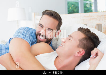 Felice coppia omosessuale giacente sul letto Foto Stock