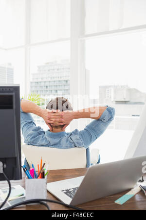 Happy businessman seduta indietro nella sua sedia Foto Stock