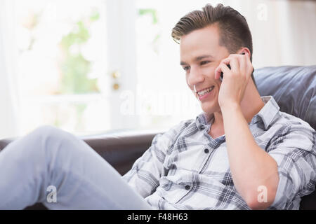 Bel giovane uomo che parla al telefono Foto Stock