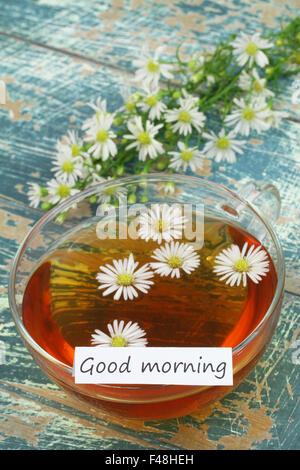 Buona mattina card con tazza di tè camomilla e freschi di fiori di camomilla Foto Stock