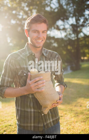 Uomo sorridente sacco di contenimento di verdure Foto Stock