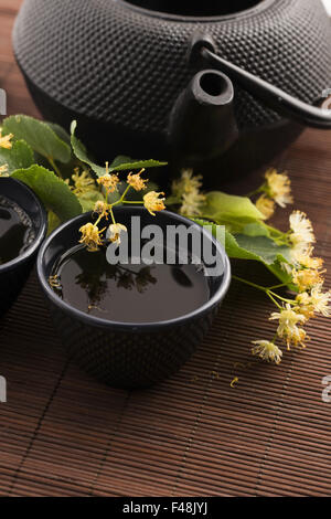 Teiera e tazza di tè di tiglio e fiori Foto Stock