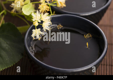 Teiera e tazza di tè di tiglio e fiori Foto Stock