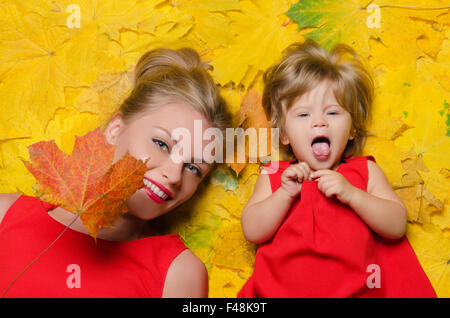 Ragazza e la giovane donna in foglie di autunno Foto Stock