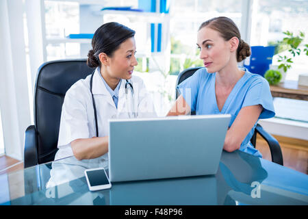 Medico e infermiere guardando al laptop Foto Stock