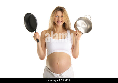 Felice donna incinta con utensili da cucina Foto Stock