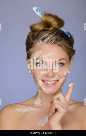 La donna nel dentifricio sul corpo e il dito Foto Stock