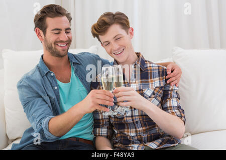 Felice coppia omosessuale la tostatura con un flute da champagne Foto Stock