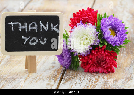La ringrazio scritto sul piccolo blackboard con colorati aster bouquet di fiori Foto Stock