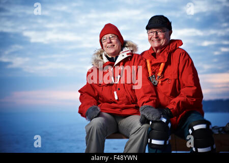 Coppia di anziani seduti su una panchina Foto Stock