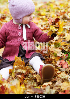 Una bambina con le foglie di autunno, Svezia. Foto Stock