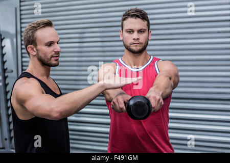 Uomo muscolare il sollevamento di un bollitore bell Foto Stock