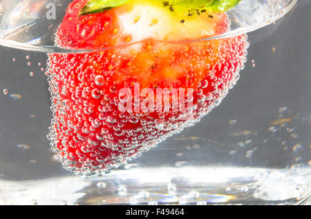 Fragola in bottiglie di vetro di acqua minerale. Foto Stock