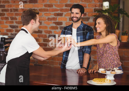 I clienti sorridenti getting take-away tazze Foto Stock