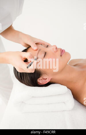 Donna utilizzando delle pinzette a molla sul sopracciglio paziente Foto Stock
