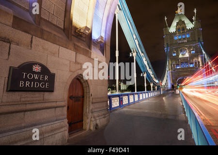 Il Tower Bridge di Londra illuminata di notte con auto luci di passaggio Foto Stock