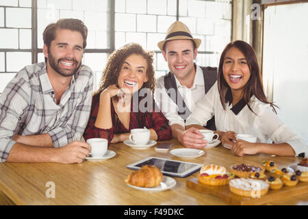 Ridere gli amici sorseggiando caffè e tratta Foto Stock