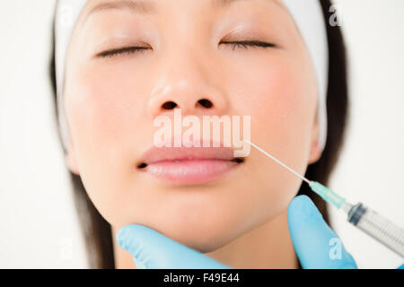 La donna riceve l'iniezione di Botox sulle labbra Foto Stock
