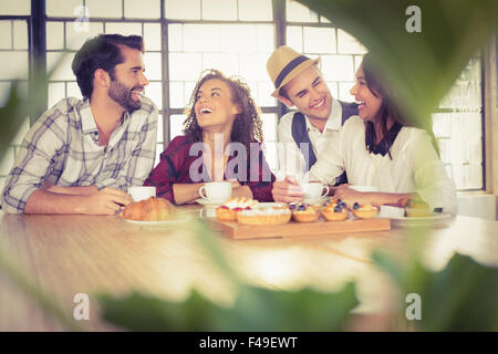 Ridere gli amici sorseggiando caffè e tratta Foto Stock