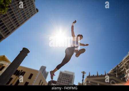 Athletic donna salta fuori il bollard Foto Stock