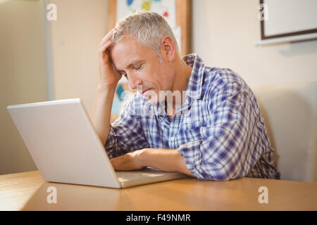 Imprenditore frustrato alla scrivania in ufficio Foto Stock