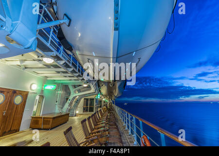 Queen Mary 2 Cunard crociera - sul ponte al tramonto. Scialuppa di salvataggio. Foto Stock