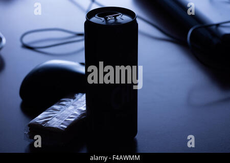 Può essere di qualche drink in silhouette con un mouse e alcuni cracker insieme con un computer portatile in una notte blu luce oscura Foto Stock